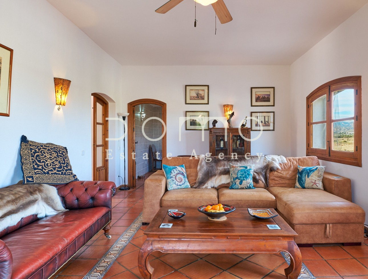 Bright and spacious living room with elegant décor, exterior views, and access to adjoining rooms.