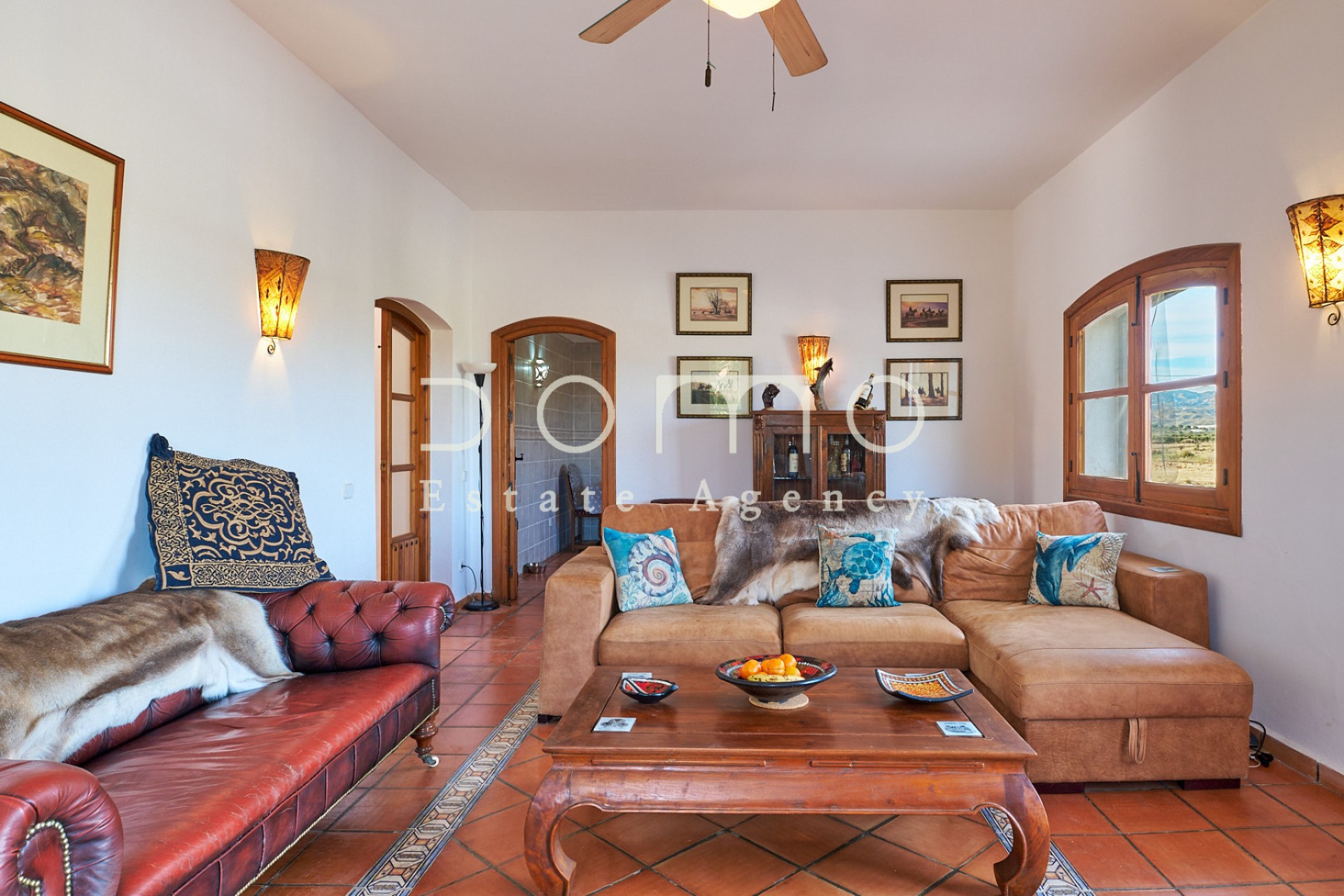 Bright and spacious living room with elegant décor, exterior views, and access to adjoining rooms.