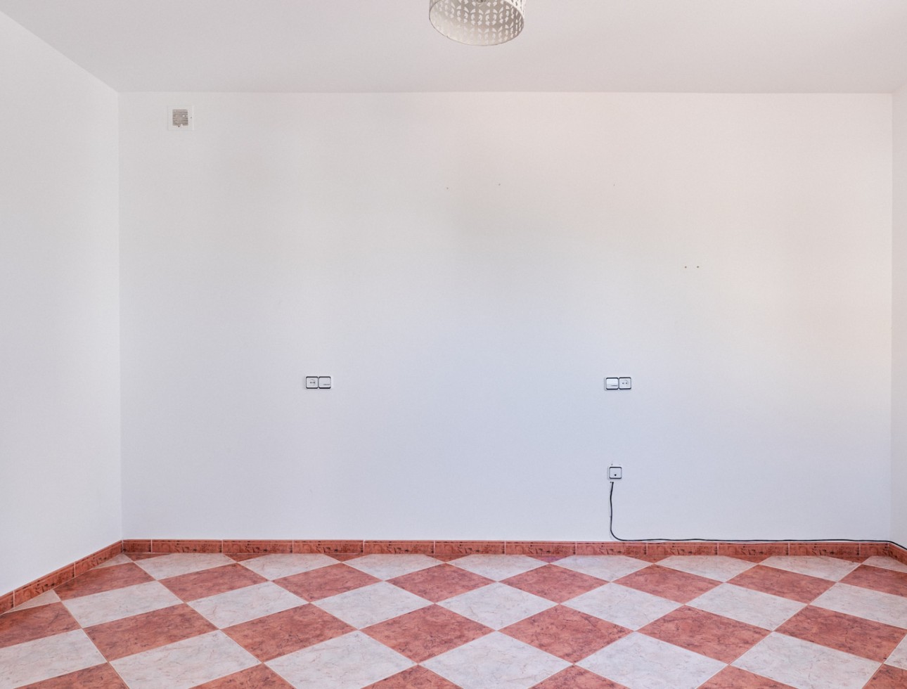 Dormitorio amplio y vacío con suelo de baldosas en villa independiente en Turre, Almería.