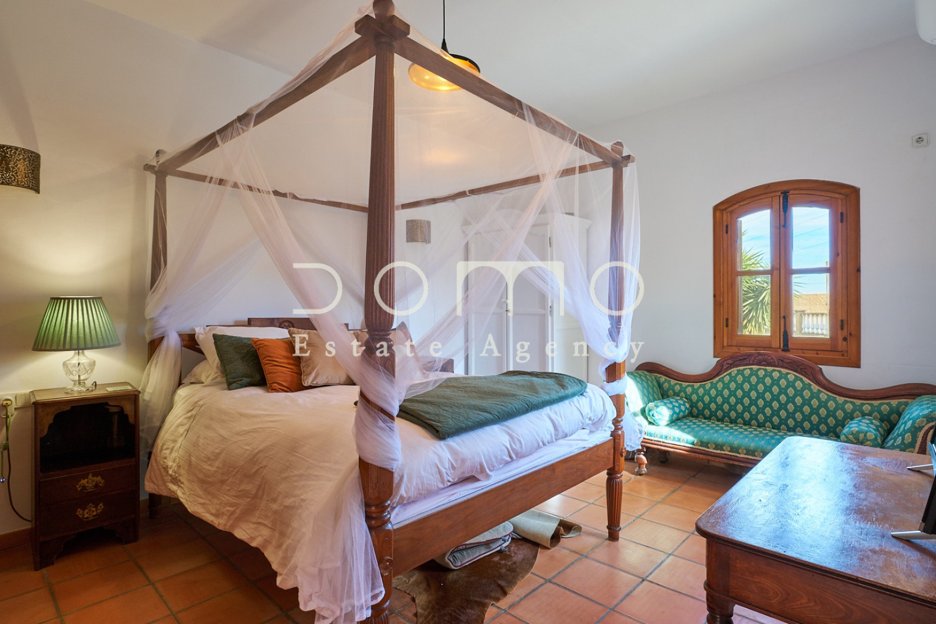 Dormitorio principal espacioso con cama de dosel y decoración rústica, muy luminoso.