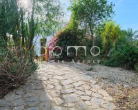 Gartenweg mit einheimischer Bepflanzung, der zum Eingang des Cortijos führt.