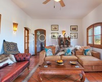 Helles, großzügiges Wohnzimmer mit eleganter Einrichtung, Außenblick und Zugang zu weiteren Räumen.