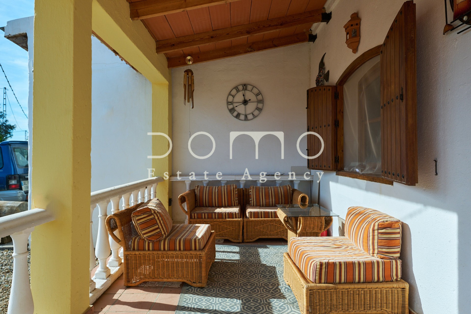 Porche cubierto del cortijo con zona de estar y mobiliario rústico, ideal para disfrutar del exterior.