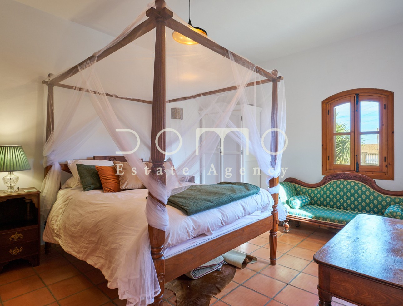 Spacious master bedroom with four-poster bed and rustic décor, filled with natural light.