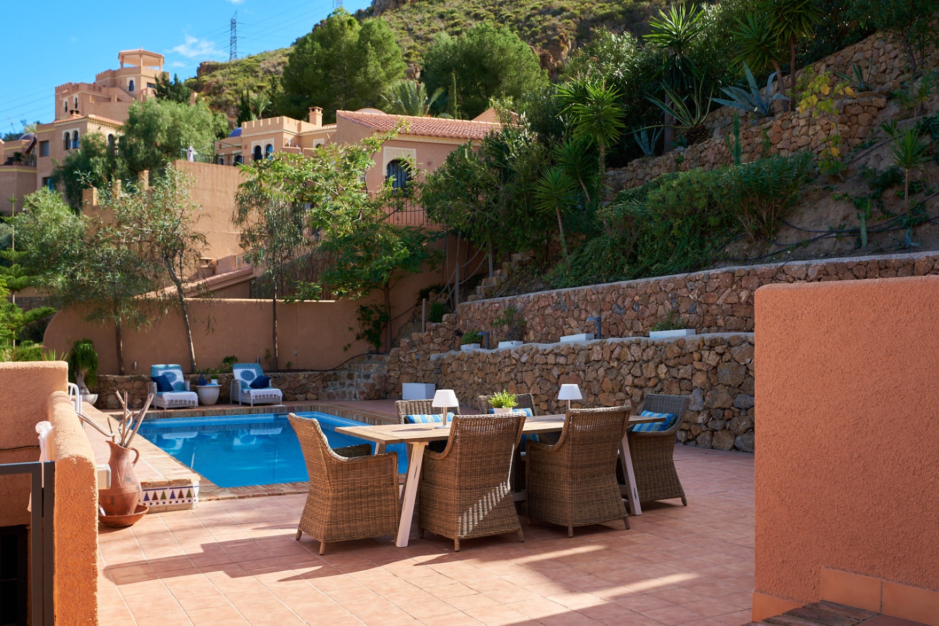 Terrasse avec piscine privée et salle à manger extérieure entourée de jardins méditerranéens à Sierra Cabrera, Almería.