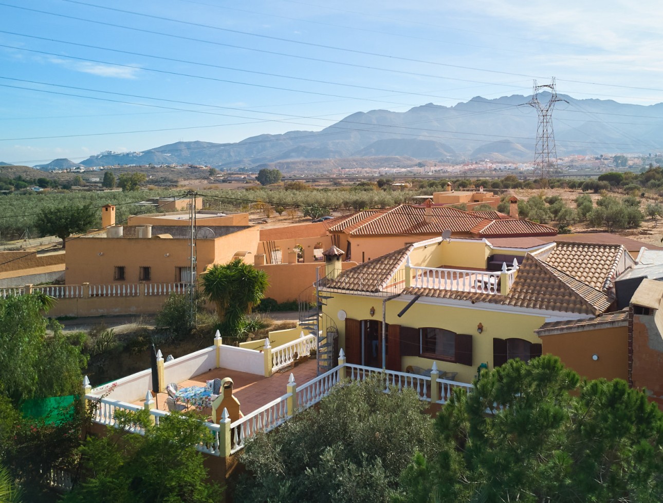Vista aérea del cortijo en Los Gallardos con terrazas, jardín y vistas abiertas a las montañas de Sierra Cabrera.