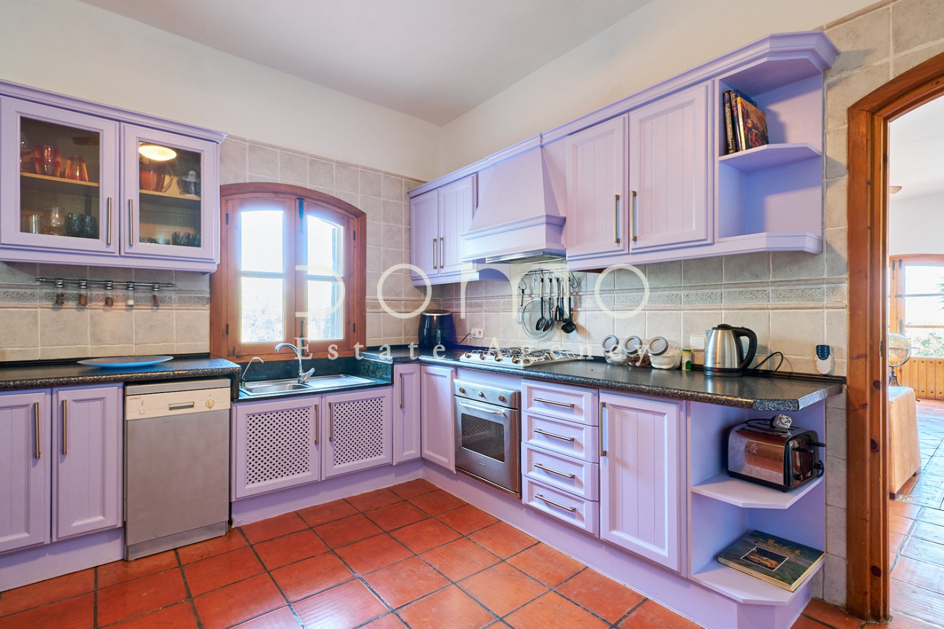 Volledig uitgeruste keuken in rustieke stijl met lavendelkleurige kasten en ingebouwde apparatuur.