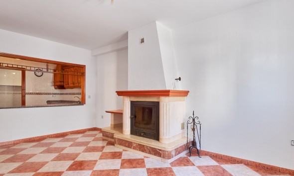 Living room with fireplace and open kitchen in villa for sale in Turre, Almería.