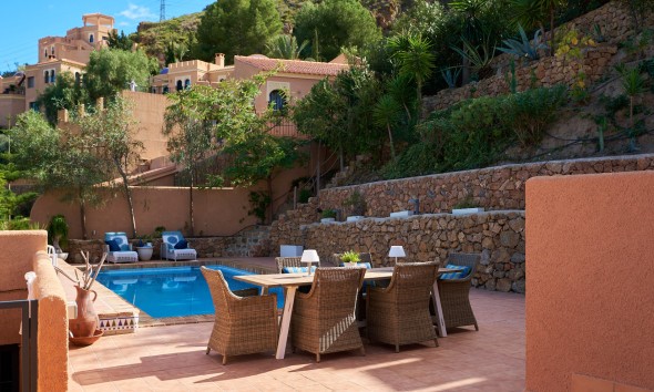 Terrace with private pool and outdoor dining area surrounded by Mediterranean gardens in Sierra Cabrera, Almería.
