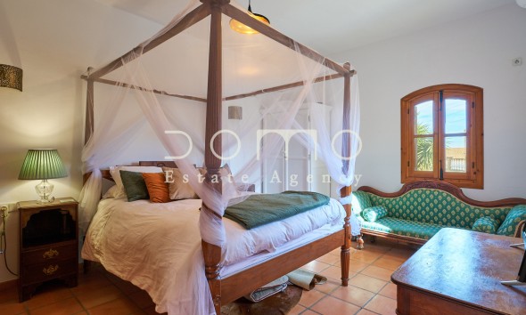 Großes Hauptschlafzimmer mit Himmelbett und rustikaler Einrichtung, sehr hell.