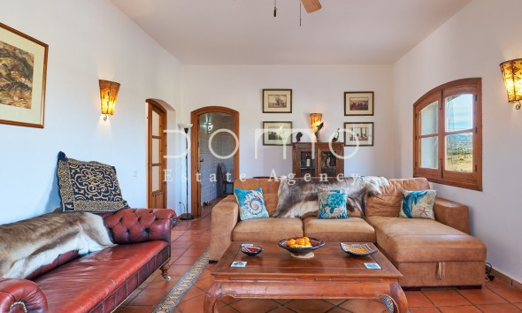 Helles, großzügiges Wohnzimmer mit eleganter Einrichtung, Außenblick und Zugang zu weiteren Räumen.